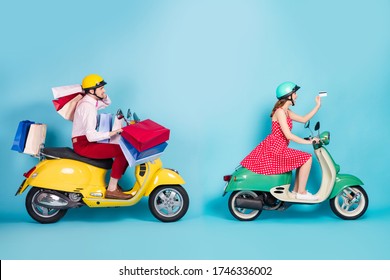 Full size profile photo of crazy shopaholic lady giving credit card exhausted guy drive retro moped carry packs shopping abroad vintage clothes protective caps isolated blue color background