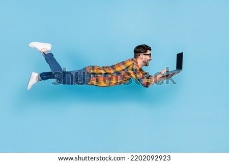 Full size profile photo of flying person use netbook write email isolated on blue color background