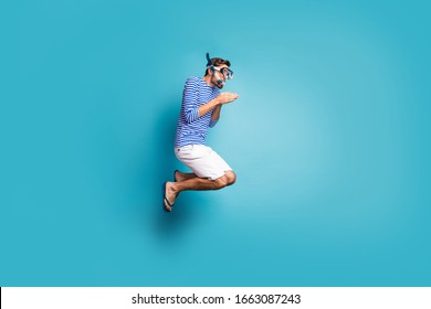 Full size profile photo of funky crazy guy tourist jump high swimming deep water mask tube diving wear striped sailor shirt vest shorts flip flops isolated blue color background - Powered by Shutterstock