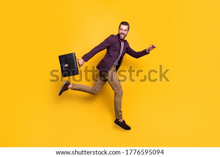Full size profile photo of handsome stylish business guy jump high up rushing work office hold briefcase wear plaid shirt blazer trousers shoes isolated yellow color background