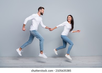 Full size profile photo of nice millennial brunet couple run wear white shirt jeans footwear isolated on grey background - Powered by Shutterstock