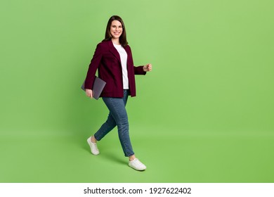 Full Size Profile Photo Of Optimistic Brown Hairdo Lady Go With Laptop Wear Spectacles Red Cardigan Jeans Sneakers Isolated On Green Color Background