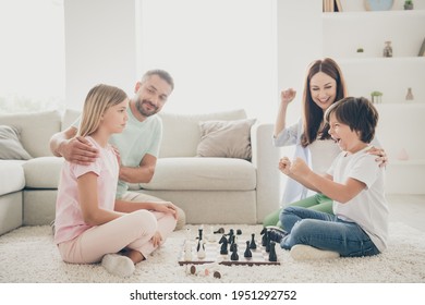 Full Size Profile Photo Of Optimistic Nice Family Mom Dad Two Kids Play Chess Win On Floor Wear T-shirts At Home