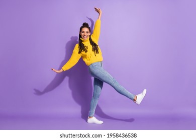Full size profile photo of optimistic nice girl dance wear sweater jeans sneakers isolated on purple background