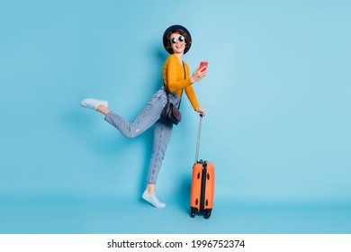 Full size profile photo of optimistic brunette short hairdo lady stand with bag wear shirt jeans sneakers isolated on blue color background