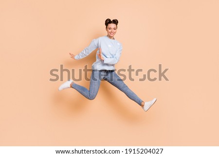 Full size profile photo of optimistic nice brunette lady jump run wear blue sweater jeans sneakers isolated on beige color background
