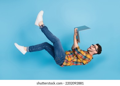 Full size profile photo of overjoyed handsome guy use netbook falling isolated on blue color background - Powered by Shutterstock