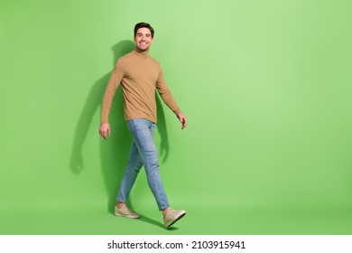 Full size profile photo of satisfied glad person walking toothy smile isolated on green color background