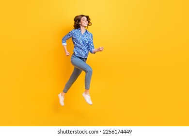 Full size profile portrait of carefree energetic girl jump running empty space isolated on yellow color background - Shutterstock ID 2256174449
