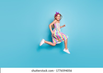 Full Size Profile Side Photo Of Cheerful Kid Girl Jump Run After Summer Season Discount Wear Stylish Trendy Purple Headband Sneakers Isolated Over Blue Color Background