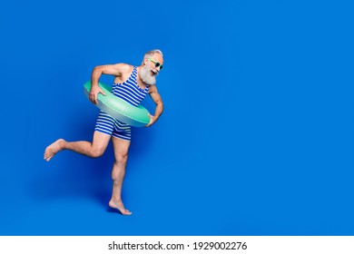 Full Size Profile Side Photo Of Mature Smiling Man With Buoy Jumping In Pool Isolated On Blue Color Background