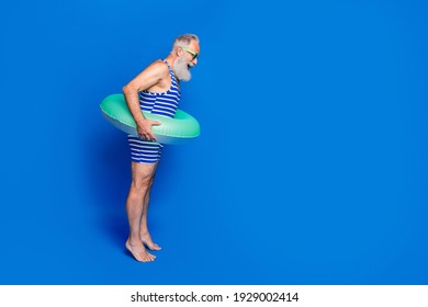 Full Size Profile Side Photo Of Shocked Amazed Old Man With Buoy Prepare To Dive Isolated On Blue Color Background