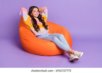 Full size profile side photo of young schoolgirl happy smile hands behind head sleep bean chair isolated over violet color background - Powered by Shutterstock