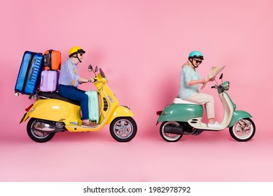 Full size profile side photo of happy mature couple ride drive moped use map summer holiday isolated on pink color background
