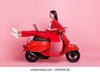 Full size profile side photo of young cheerful lovely businesswoman sit moped working in laptop isolated on pink color background