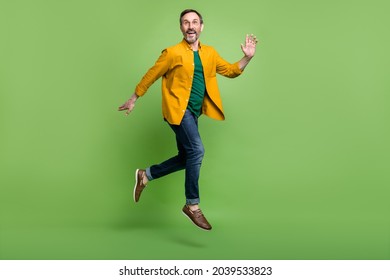 Full Size Profile Side Photo Of Mature Man Happy Positive Smile Jump Go Walk Run Isolated Over Green Color Background