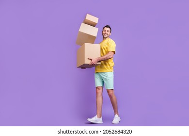 Full size profile side photo of young guy happy positive smile hold cardboard delivery isolated over purple color background - Powered by Shutterstock