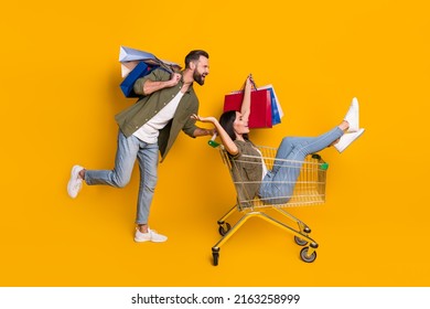 Full Size Profile Side Photo Of Young Girl Guy Fast Rush Shopping Center Discount Isolated Over Yellow Color Background