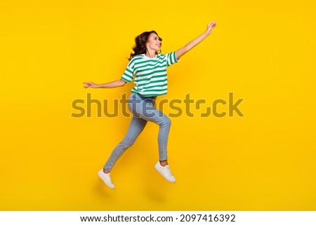 Full size profile side photo of youth lady run walk try to catch look empty space isolated over yellow color background