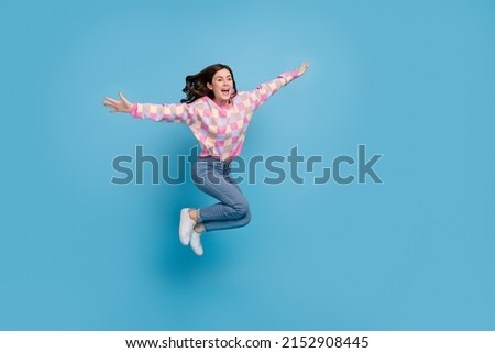 Full size profile side photo of young cheerful girl have fun dream hands wings isolated over blue color background