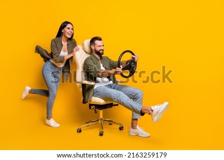 Full size profile side photo of young girl guy sit stool play videogame fast speed transport isolated over yellow color background
