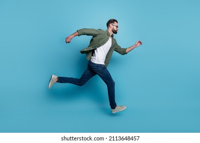 Full size profile side running fast speed traveling look copyspace casual wear isolated on blue color background - Powered by Shutterstock