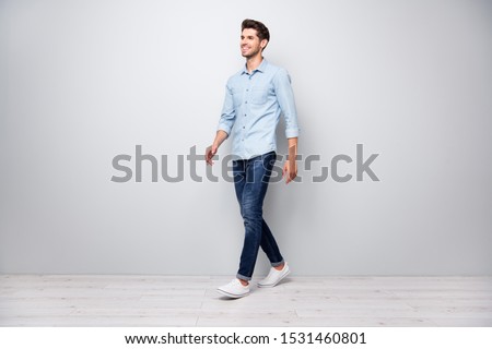 Full size turned photo of positive cheerful man have free time fun go walk want meet university friends wear casual style clothes isolated over grey color background