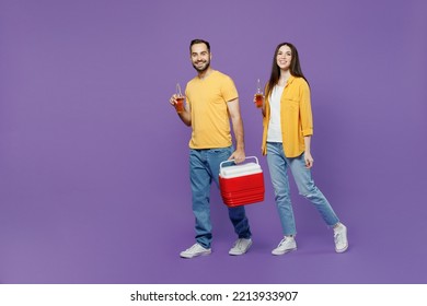 Full Size Young Couple Two Friends Family Man Woman Together Wear Yellow Clothes Hold Red Box Freezer Cooler Refrigerator Bottle Drink Beer Walk Go Isolated On Plain Violet Background Studio Portrait