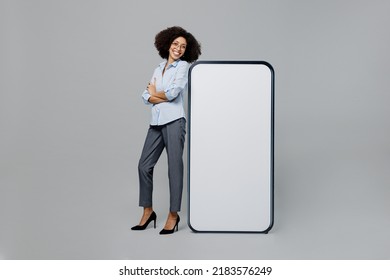 Full Size Young Employee Business Corporate Lawyer Woman Of African American Ethnicity In Shirt Work In Office Near Big Blank Screen Mobile Cell Phone Workspace Mockup Area Isolated On Grey Background