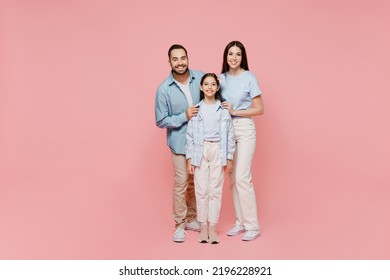 Full size young happy caucasian smiling fun parents mom dad with child kid daughter teen girl in blue clothes look camera hug cuddle isolated on plain pastel light pink background. Family day concept - Shutterstock ID 2196228921