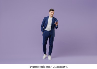 Full size young successful employee business man lawyer 20s wear formal blue suit white t-shirt move stroll hold use mobile cell phone hand in pocket isolated pastel purple background studio portrait - Shutterstock ID 2178585041