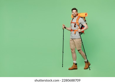 Full size young traveler white man carry backpack stuff mat walk with trakking poles isolated on plain green background. Tourist leads active healthy lifestyle. Hiking trek rest travel trip concept - Shutterstock ID 2280688709