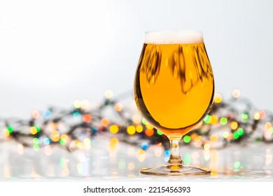 Full Snifter Glass Of Lager Of Pilsner Beer With Christmas Lights On White Background