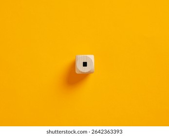 Full stop or dot punctuation mark on a wooden cube on vibrant yellow background. To put an end or to stop concepts.
