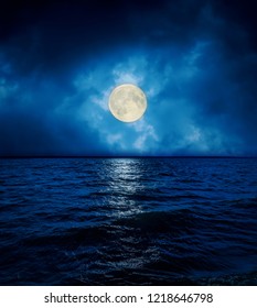 Full Super Moon In Dramatic Clouds Over Dark Water