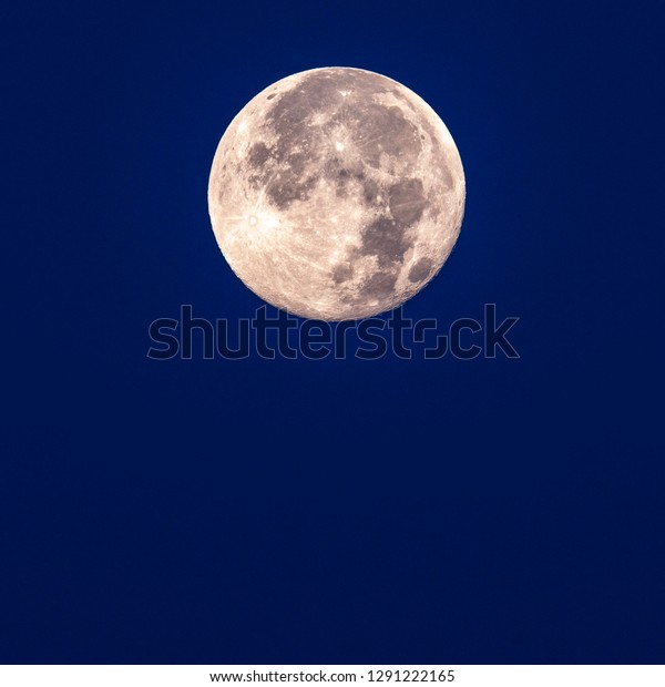 Full super\
moon taken at dawn with clear blue\
sky