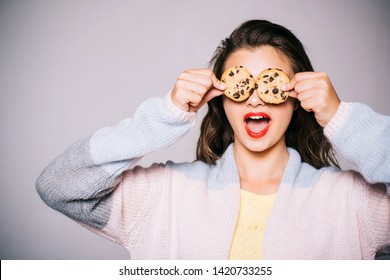 Full of sweet chocolate flavors. Cute girl having fun with cookies. Pretty girl covering eyes with cookies. Bakery style chocolate chip cookie recipe. Bakery shop. Following a cooking recipe. - Powered by Shutterstock
