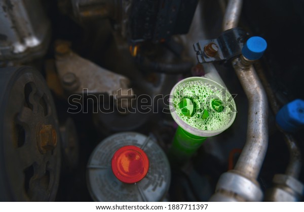 Full tank of green washer fluid.\
Filling windscreen water reservoir with antifreeze washer\
fluid