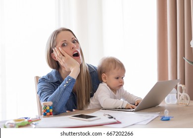 Full Time Mom In Shock Working On Computer With Child In Lap