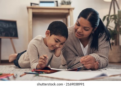 Full Time Parent, Part Time Teacher. Shot Of An Adorable Little Boy Completing A School Assignment With His Mother At Home.