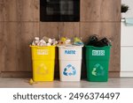 Full trash bins with different types of garbage in kitchen. Recycling concept