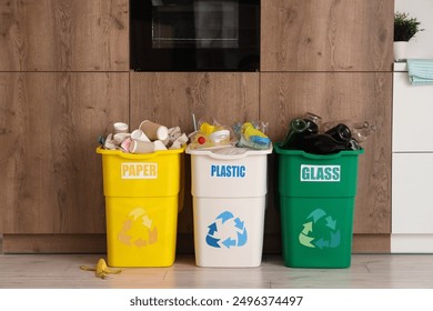 Full trash bins with different types of garbage in kitchen. Recycling concept