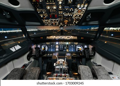Full view of cockpit modern Boeing aircraft before take-off. Airplane is ready to fly. Night shot in cabin. Safety flight