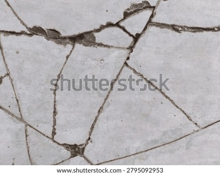 A full view of cracked and broken ceramic tiles with dark cement lines, creating an irregular abstract mosaic textured background.