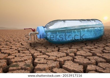 Full water of plastic bottle with water taps on dry cracked earth metaphor water crisis, scarcity and drought on summer. Lack of fresh water concept.