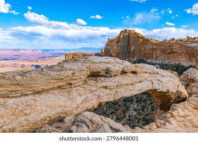 Full wide-angle view of the dramatic Mesa Arch spanning across the cliff edge, overlooking the massive desert basins of Moab, Utah.