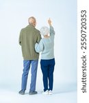 Full-body photo of a senior couple looking up from behind