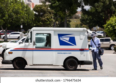 Fullerton, California / USA - August 13, 2020: A USPS (United States Parcel Service) Mail Truck And Postal Carrier Make A Delivery.