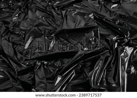 full-frame abstract background of crumpled black plastic film bag.