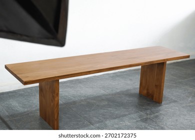 A full-frame product shot of a long, rectangular wooden bench or low console table